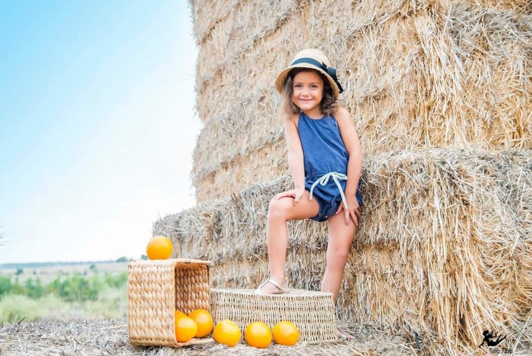 Young girl staying behind orange basket