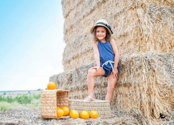 Young girl staying behind orange basket